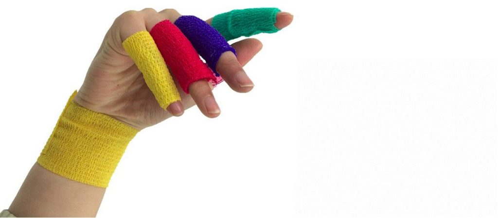 The writs and four fingers of a hand are wrapped in yellow, red, blue, and green cohesive bandage while in front of a white background