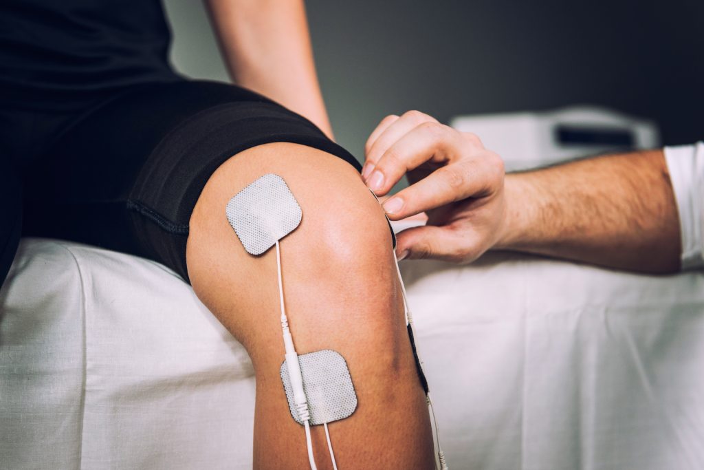 Electrodes placed on knee for electrical stimulation to treat knee pain.