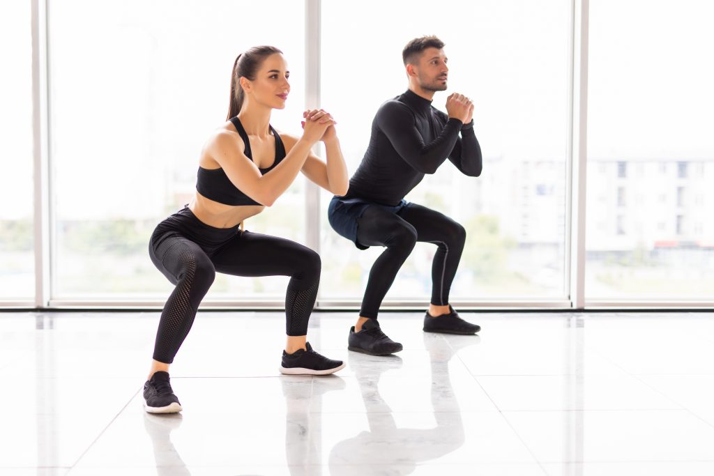 Image shows couple doing squats.