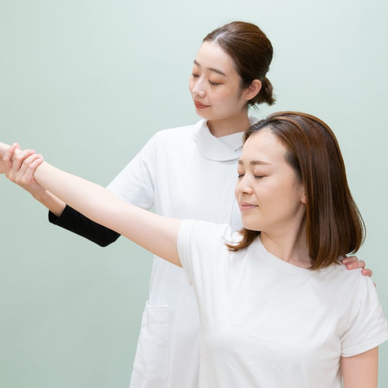 Physiotherapist conducting frozen shoulder range of motion exercise.