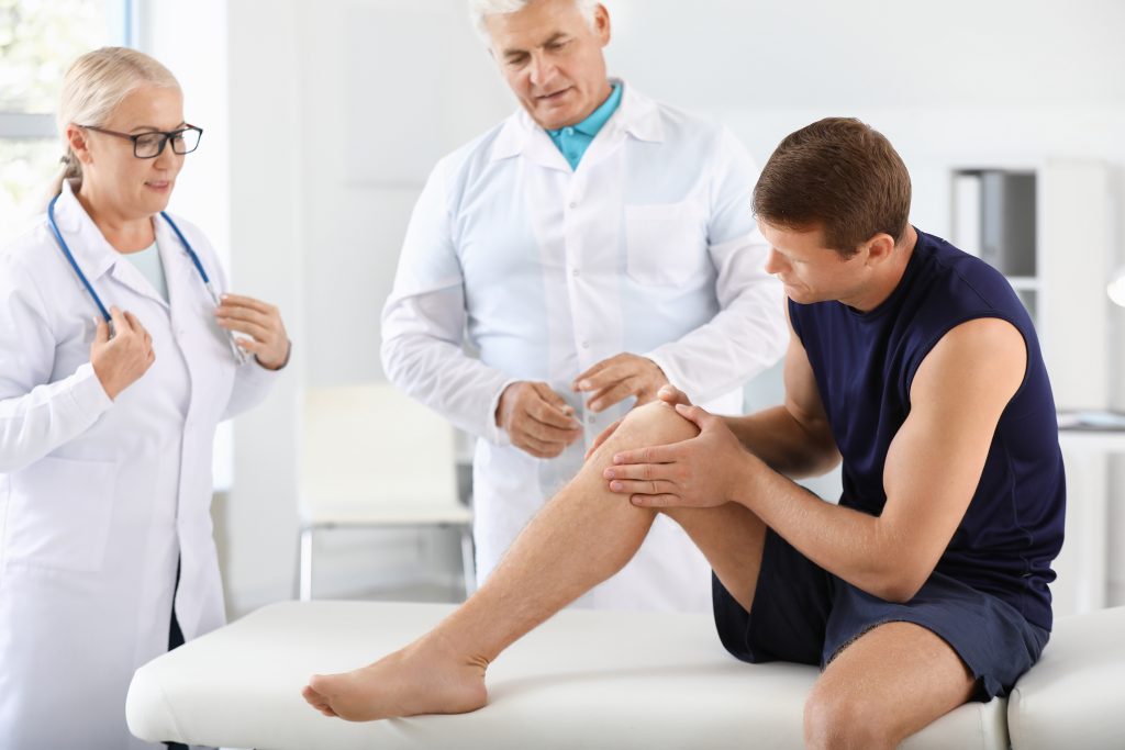 Doctors examining patient's knee pain
