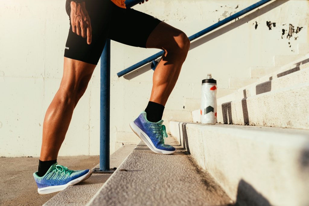 Man stretching his calves using the stairs.