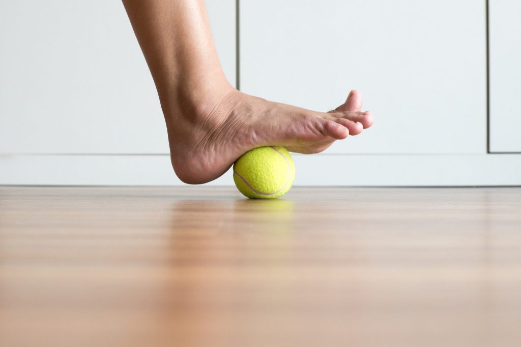 Image shows rolling the foot over a tennis ball.