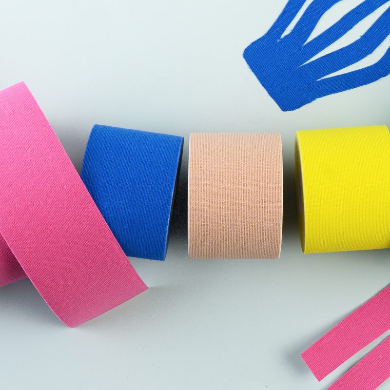 image shows various rolls of kinesiology tape and athletic tape