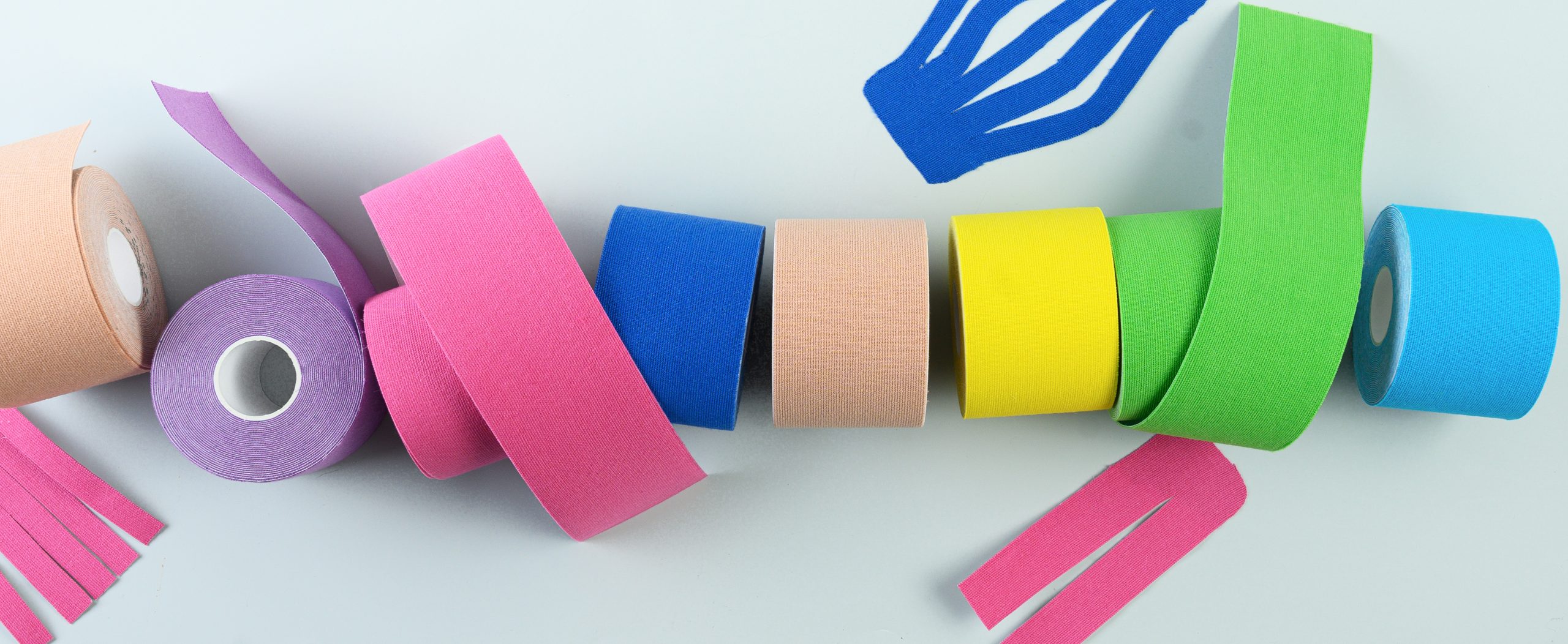 image shows various rolls of kinesiology tape and athletic tape