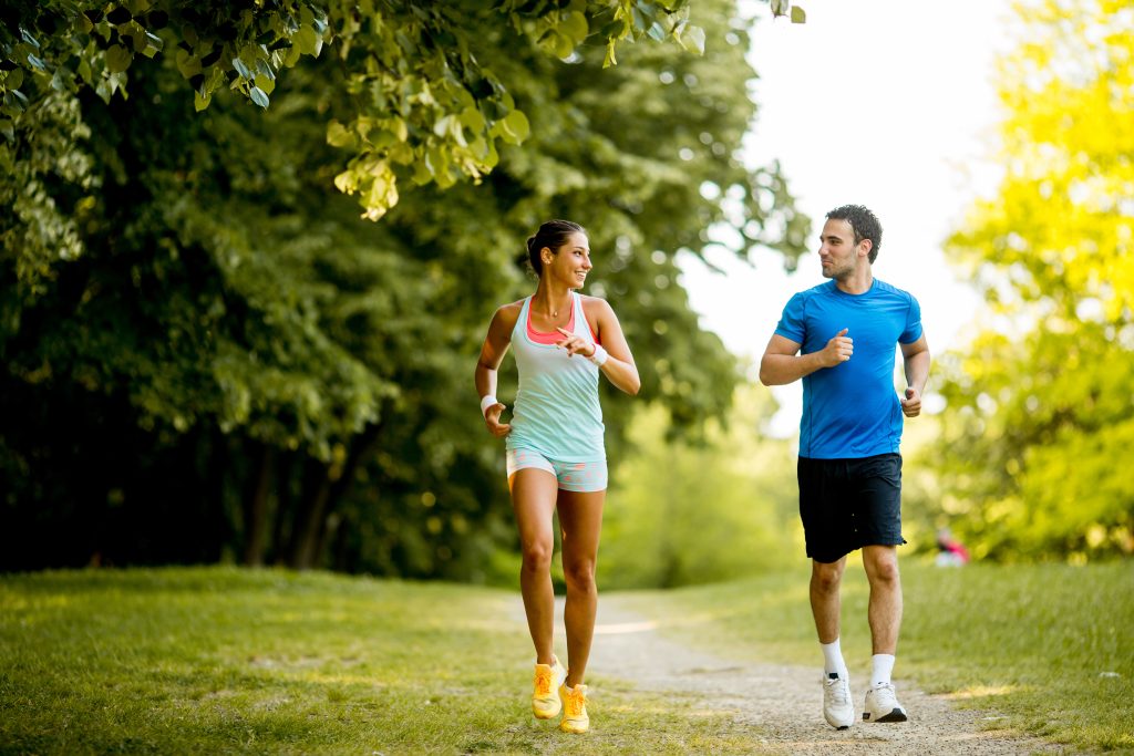 Young couple running wearing proper footwear to prevent ITBS.