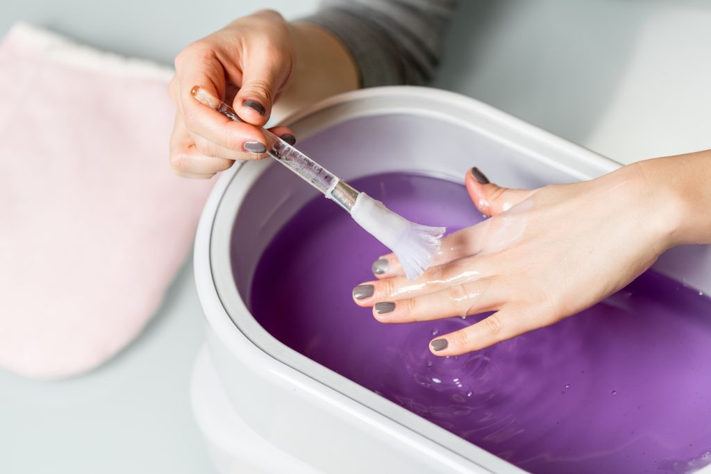Image shows brushing method used in paraffin wax bath therapy.