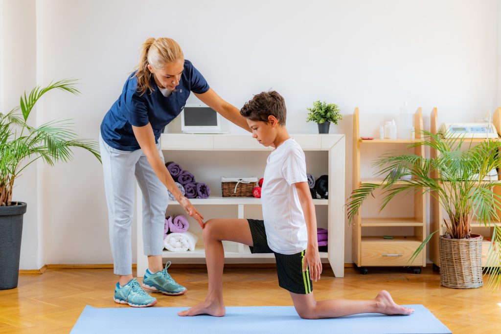 Young male having flexibility exercise with a physical therapist.