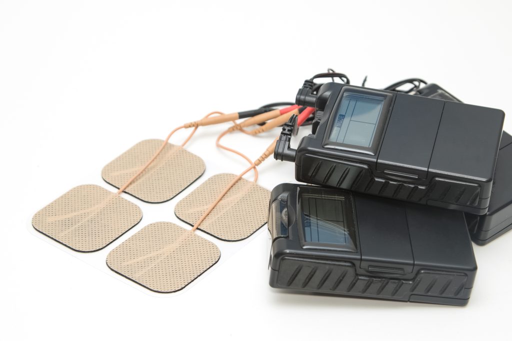 Image shows TENS device with tens pads used in physical therapy.