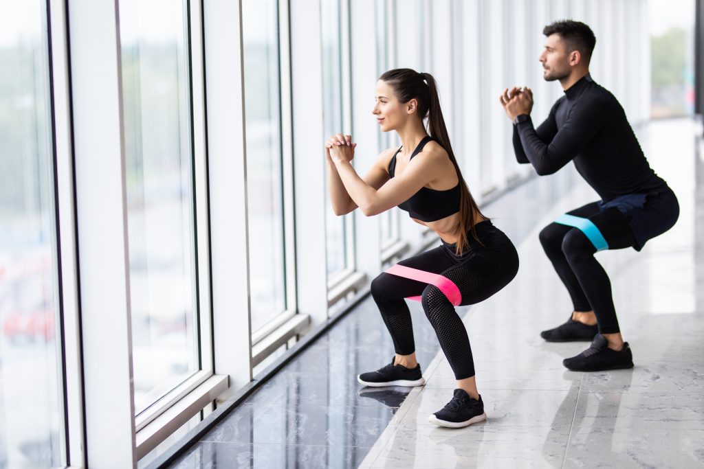 Couple doing fitness exercise using resistance bands.