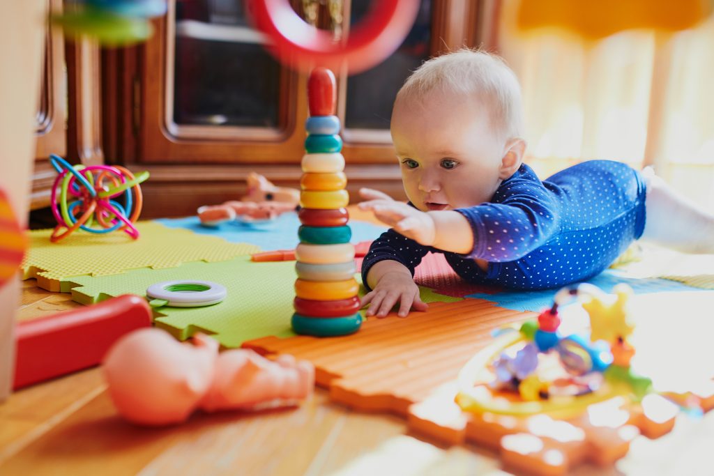 Baby reaching her toy while on tummy time.