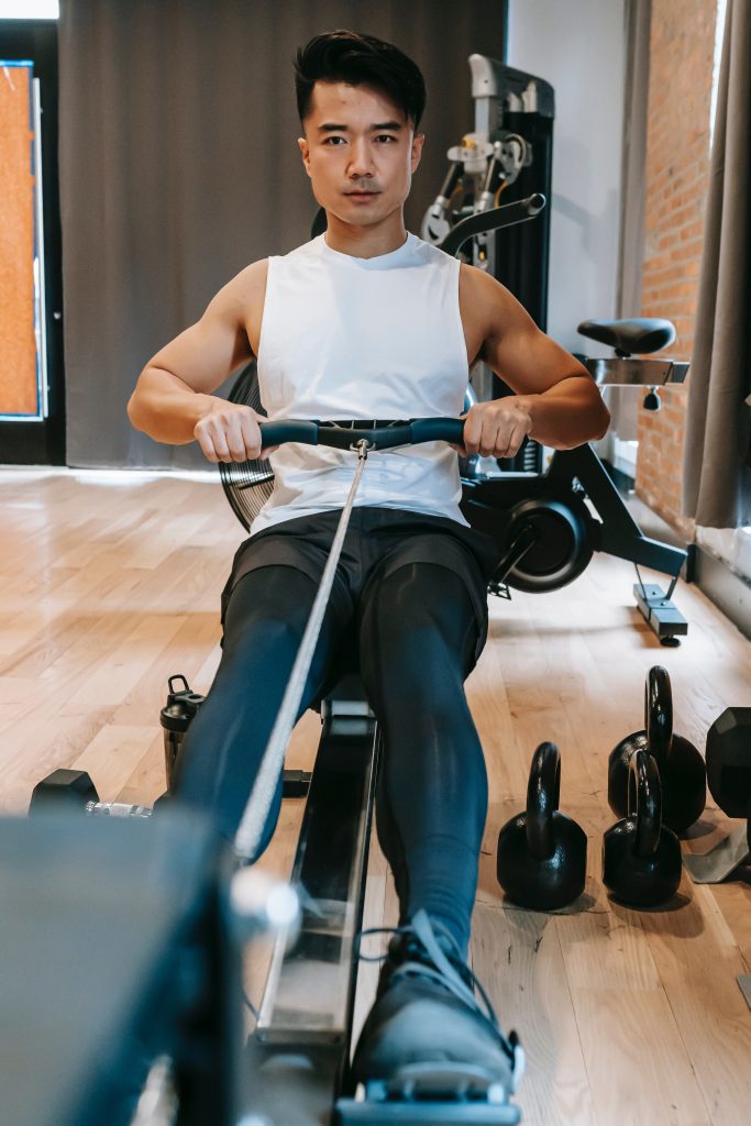 Man doing rowing exercise on a machine which is a non-impact cardio exercise.