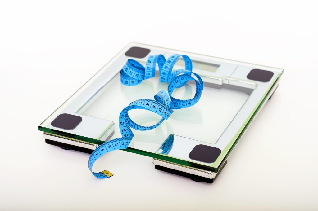 Weighing scale and a tape measure which illustrates weight regulation.