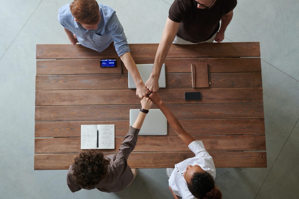 Group of people sealing the deal with a powerful fist bump.