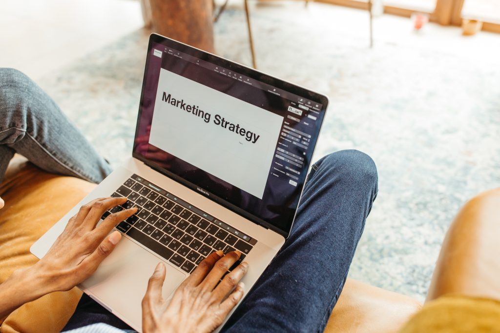 A person is typing on a laptop on their lap