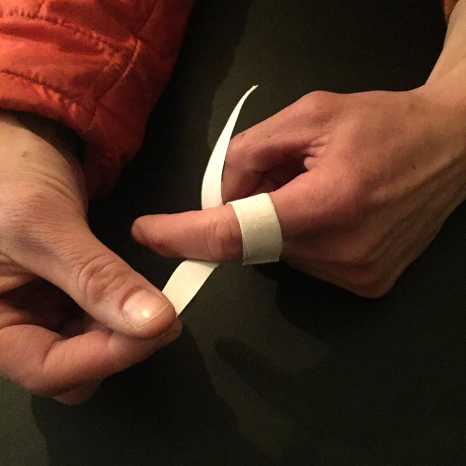 a finger being taped with Brazilian jiu-jitsu tape