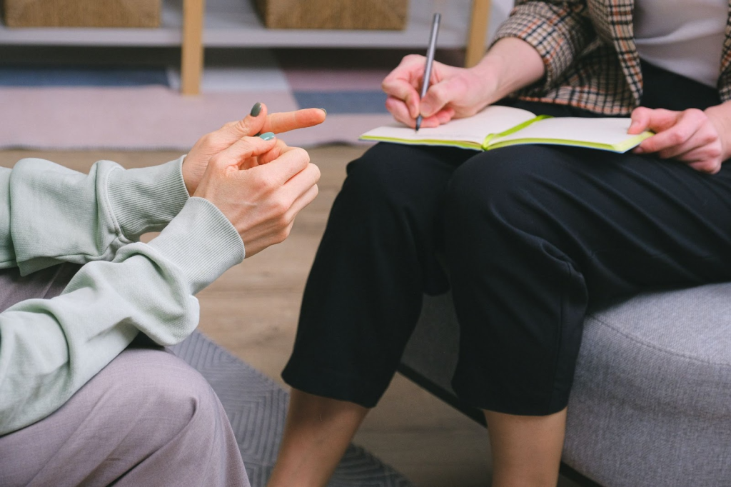 physiotherapist taking in feedback from a client while sitting down and facing each other