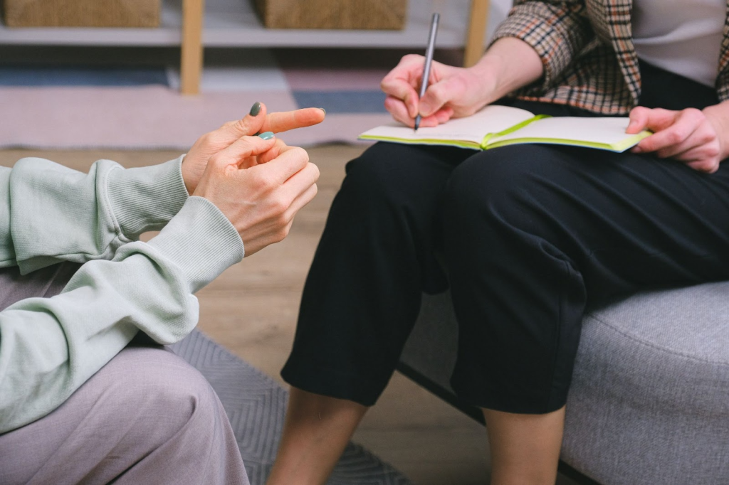 physiotherapist taking in  feedback from a client while sitting down and facing each other