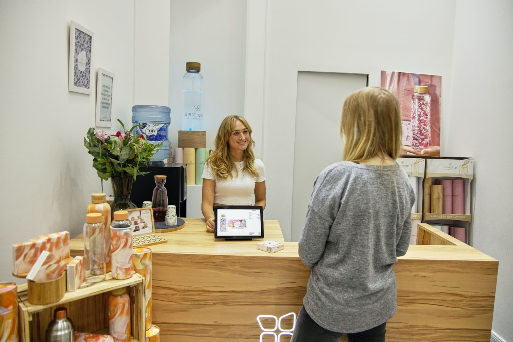 front desk staff offering a catalogue and other products to a potential buyer at the clinic