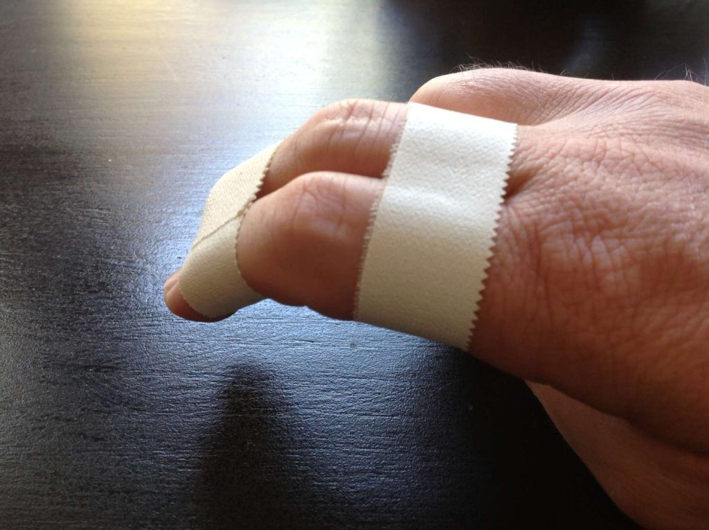 two fingers taped together with Brazilian jiu-jitsu tape