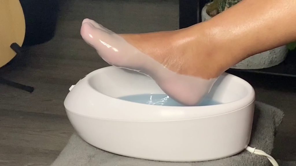 A foot is dipped in a melted paraffin wax treatment 