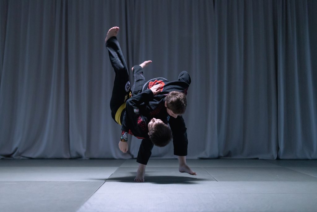 Two people practicing jiu-jitsu while wearing black uniforms