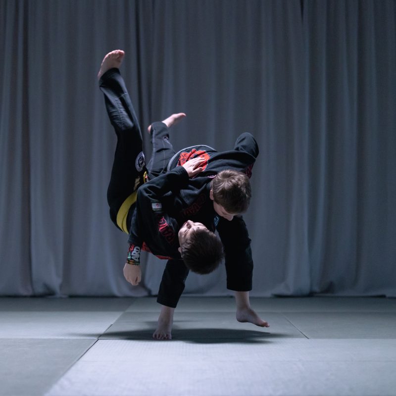 Two people practicing jiu-jitsu while wearing black uniforms
