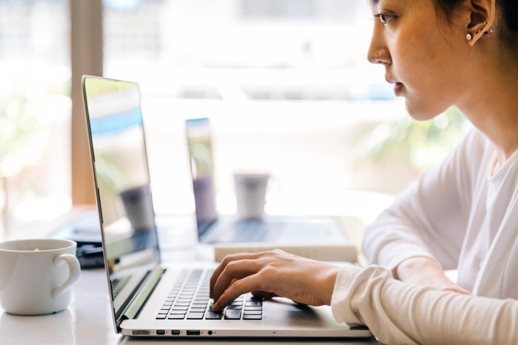 a physiotherapist using thing their computer for the DOH exam while sitting down at a desk