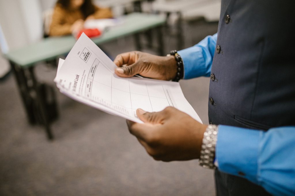 a person holding papers in their hands while standing