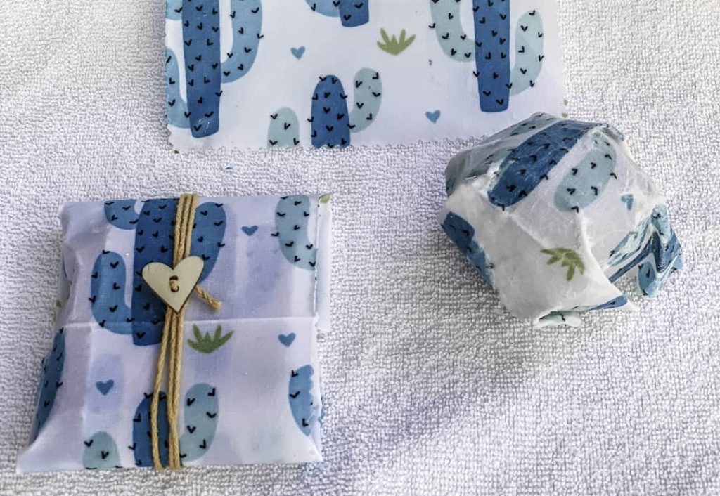 Handmade food wraps with blue cacti on them wrapping food with ties while on a table