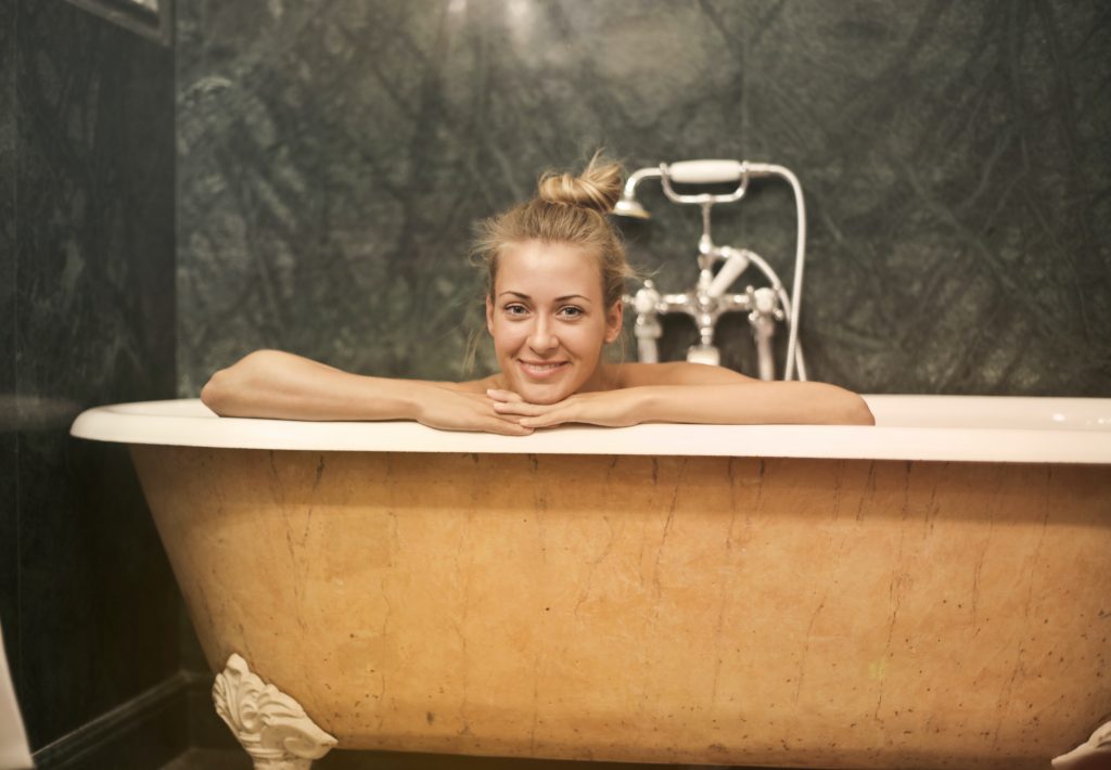 A lady is enjoying her Epsom salt bath in her porcelain bathtub 