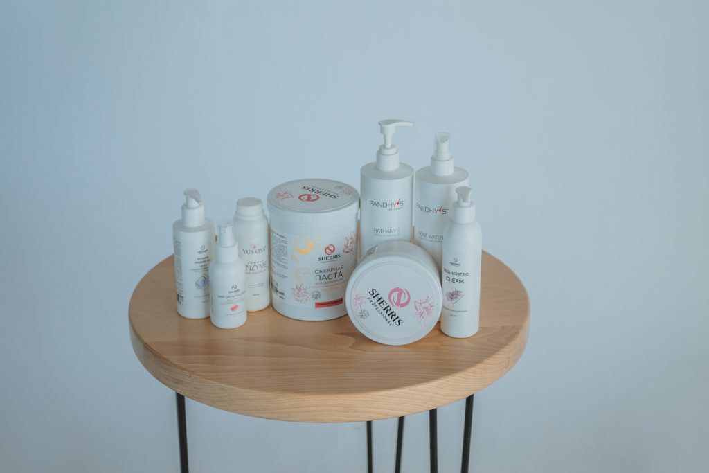A sample display of the physiotherapy products are on a small, circular, wooden table in front of a bluish wall