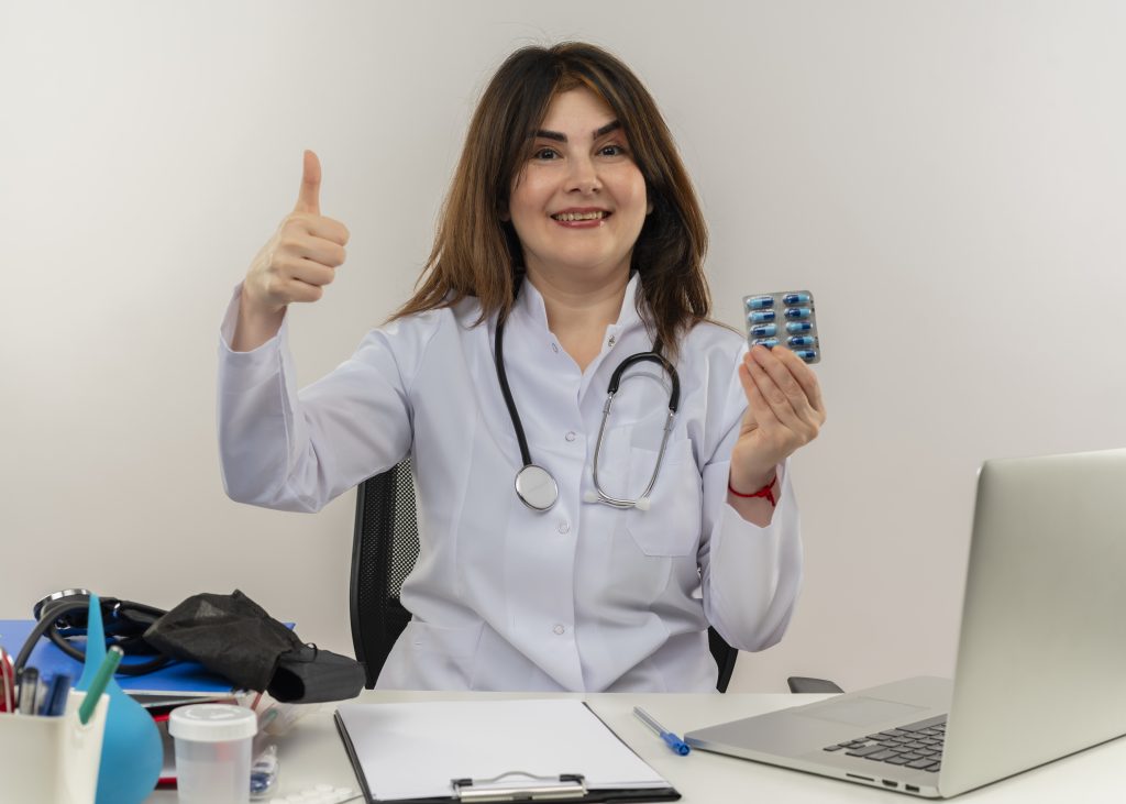 A physiotherapist is helping a client decide which product they should get while holding it for them and showing their approval through a smile and a thumbs up