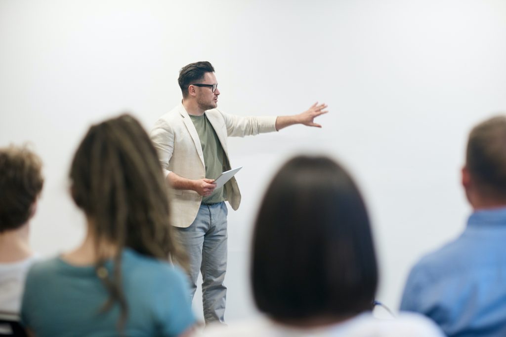 A physiotherapist is in front of a class being a professor, teaching the next generation of physiotherapists what they need to know to do the job right