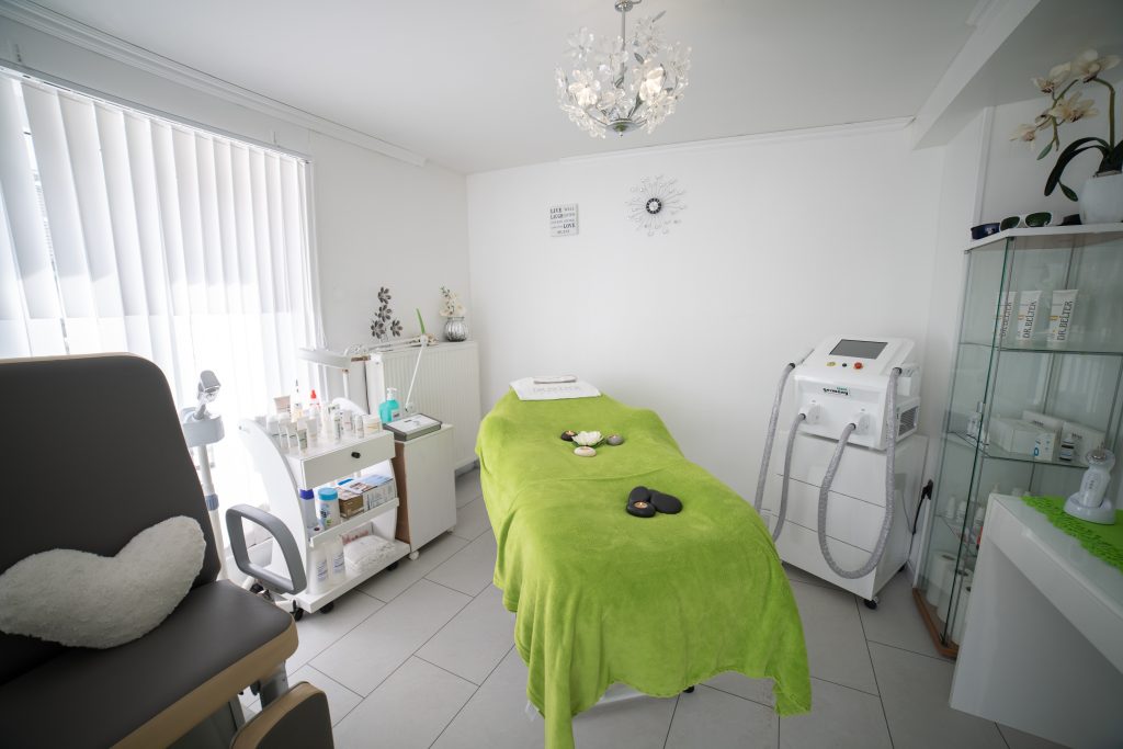 A room in a physiotherapy clinic is full with the supplier a physiotherapist needs, along with green blanket and a massage bed