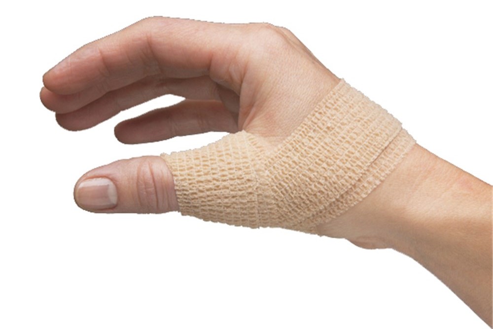 A hand is wrapped in beige cohesive bandage while in front of a white background