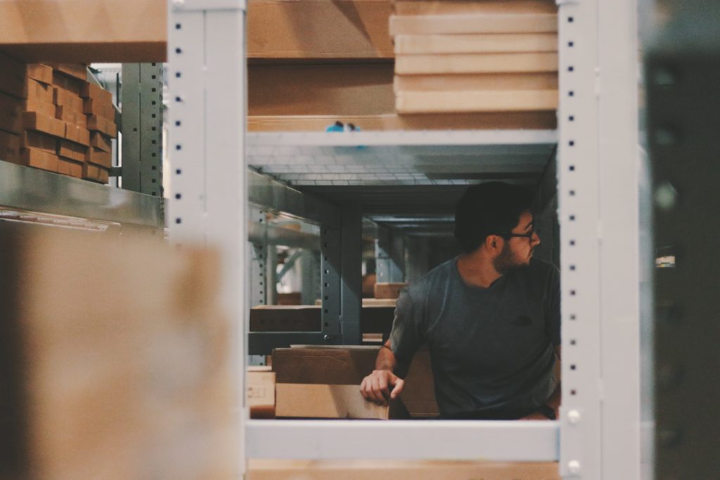 Staff at a physiotherapy clinic is checking the inventory first in a room full of metal shelves and boxes before ordering anything