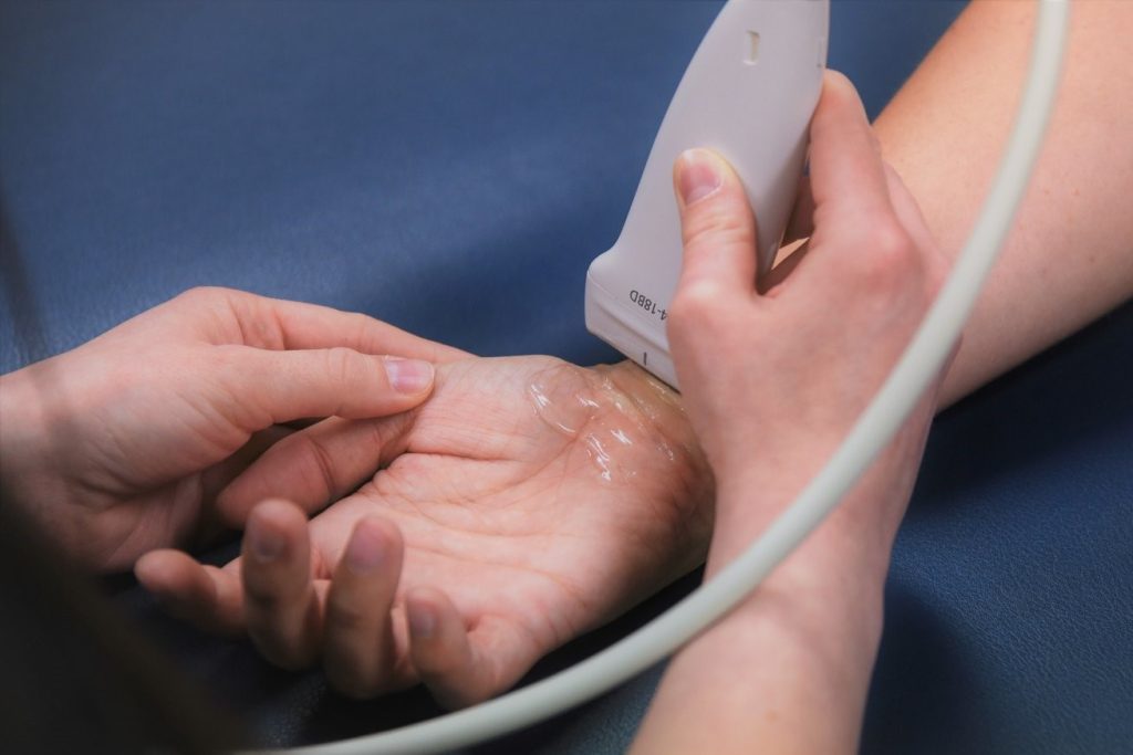 A physiotherapist is using an ultrasound machine on a patient who could have carpal tunnel syndrome