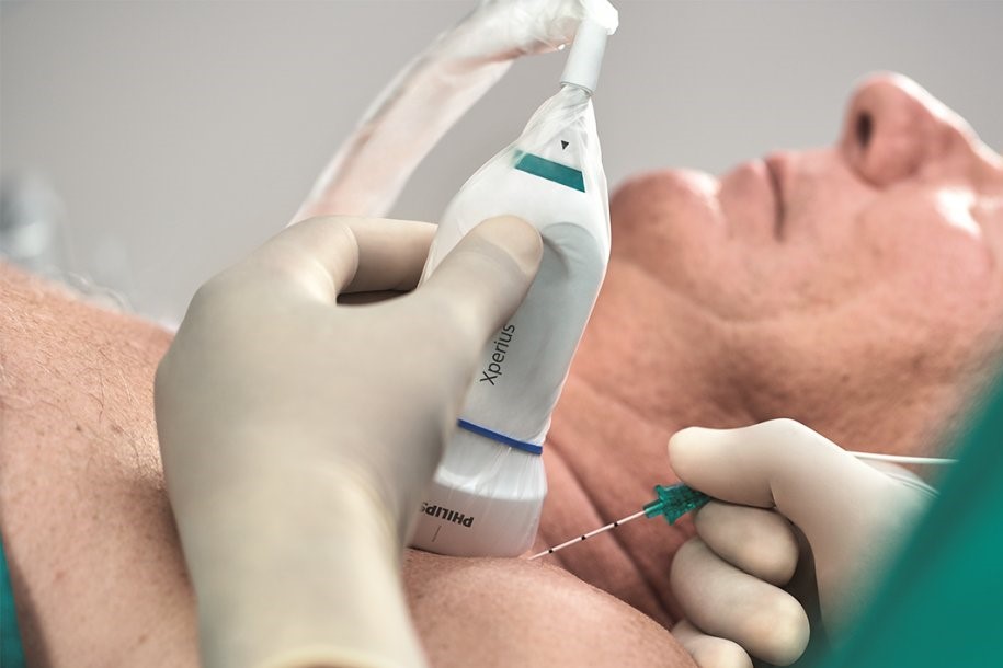 A medical professional is using an ultrasound machine to properly place a needle for anesthesia
