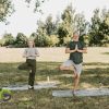 An older man and woman practicing yoga in a park.