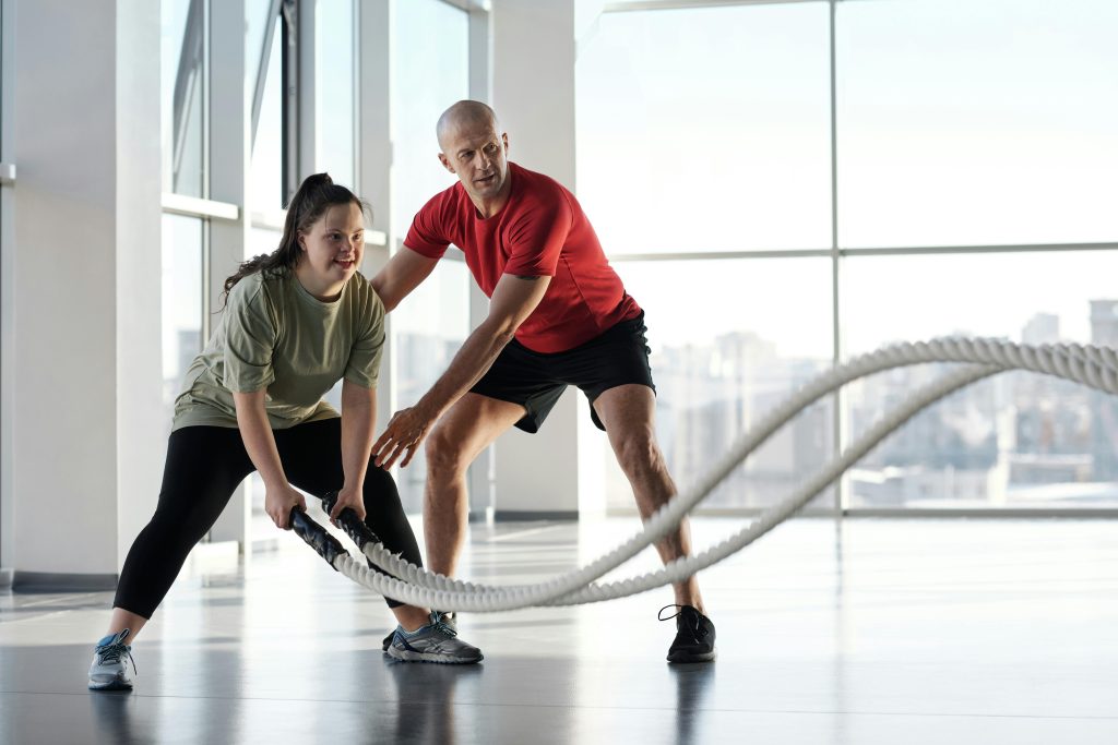 A woman working out with the help of her trainer