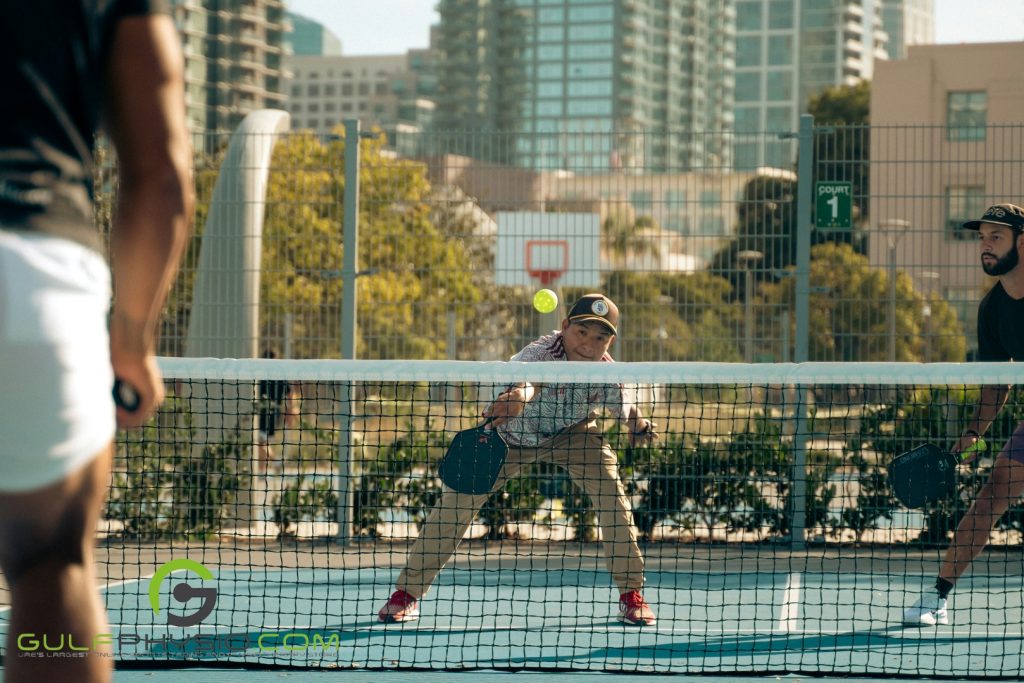 A group of men playing pickleball.