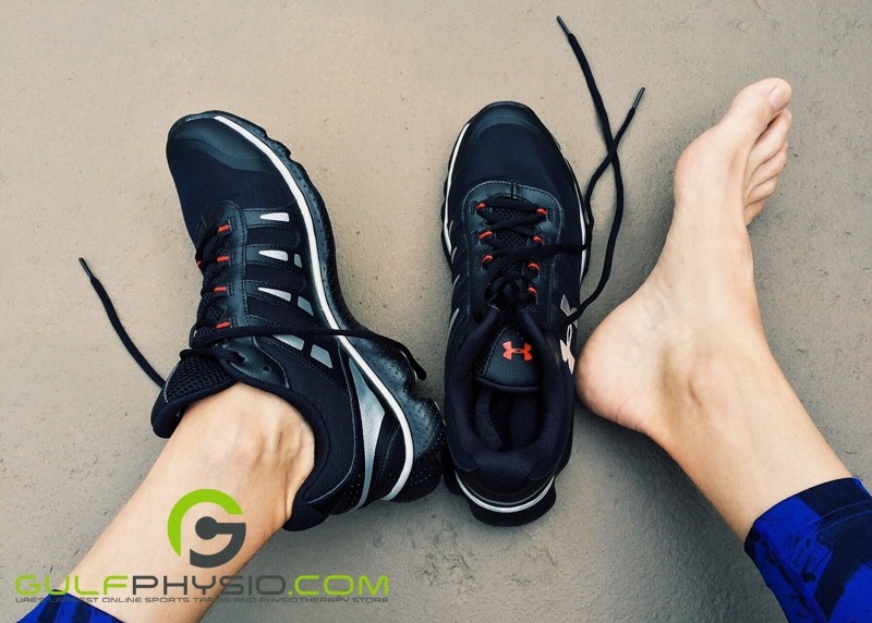 A photo of a runner’s feet.The right shoe has been taken off to reveal a bare foot.